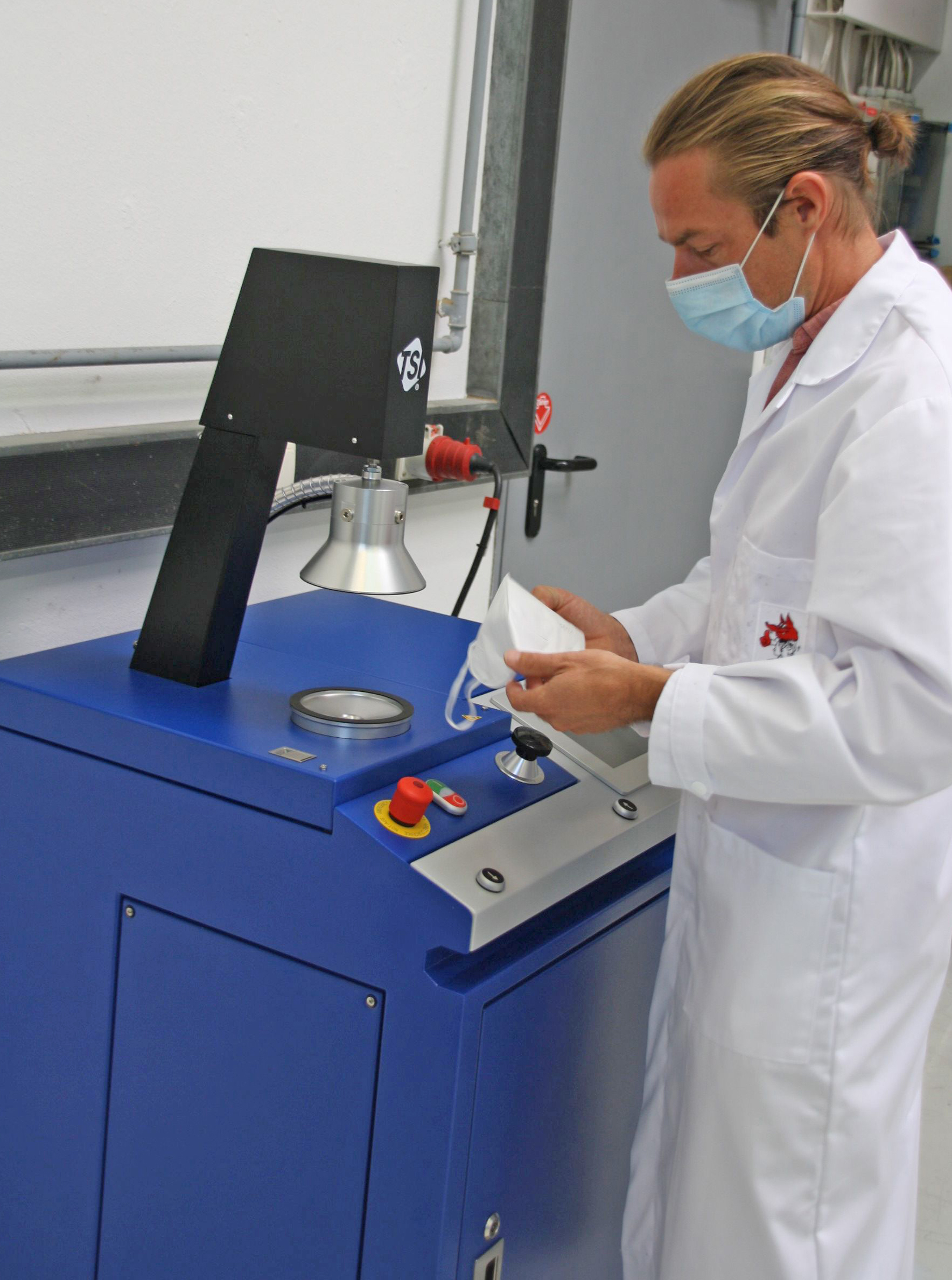 Das Foto zeigt einen ift-Prüfer im Labor bei der Prüfung der Partikelfilterwirkung einer Maske und Durchlass des Filtermediums gemäß EN 149, EN 405 (Quelle: ift Rosenheim)