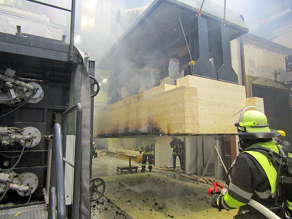 Das Foto zeigt Feuerwehrleute beim Löschen nach einer Brandprüfung.
