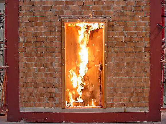 Das Foto zeigt eine brennende Innentür während einer Brandprüfung am ift Rosenheim.