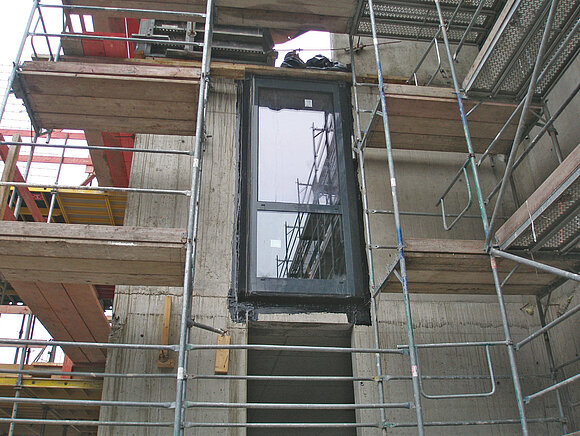 Das Foto zeigt ein eingebautes Fenster auf einer Baustelle.