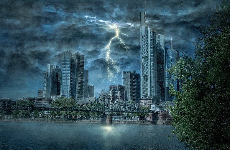 Eine Stadt in der ein Gewitter herrscht und ein Blitz einschlägt.