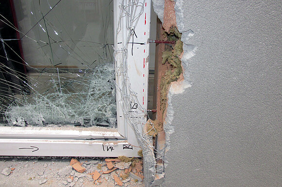 Nahaufnahme eines demolierten Fensters durch Leibungsangriff.