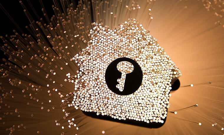 Foto eines Hauses, das aus Draht besteht, mit einem Schlüsselsymbol drauf